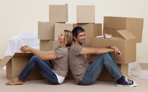 Movers carrying furniture through a local Tooting property entrance