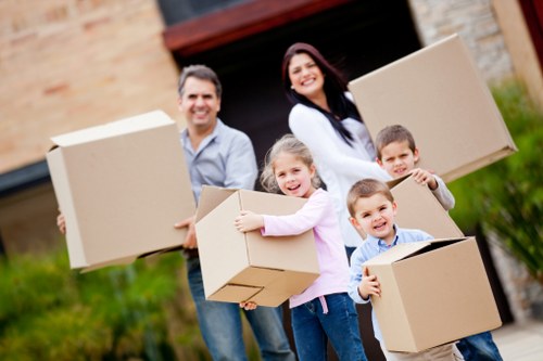 Removal team carrying furniture down stairs in a Tooting property