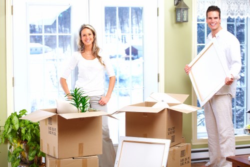 Team members carrying a heavy item carefully through a property
